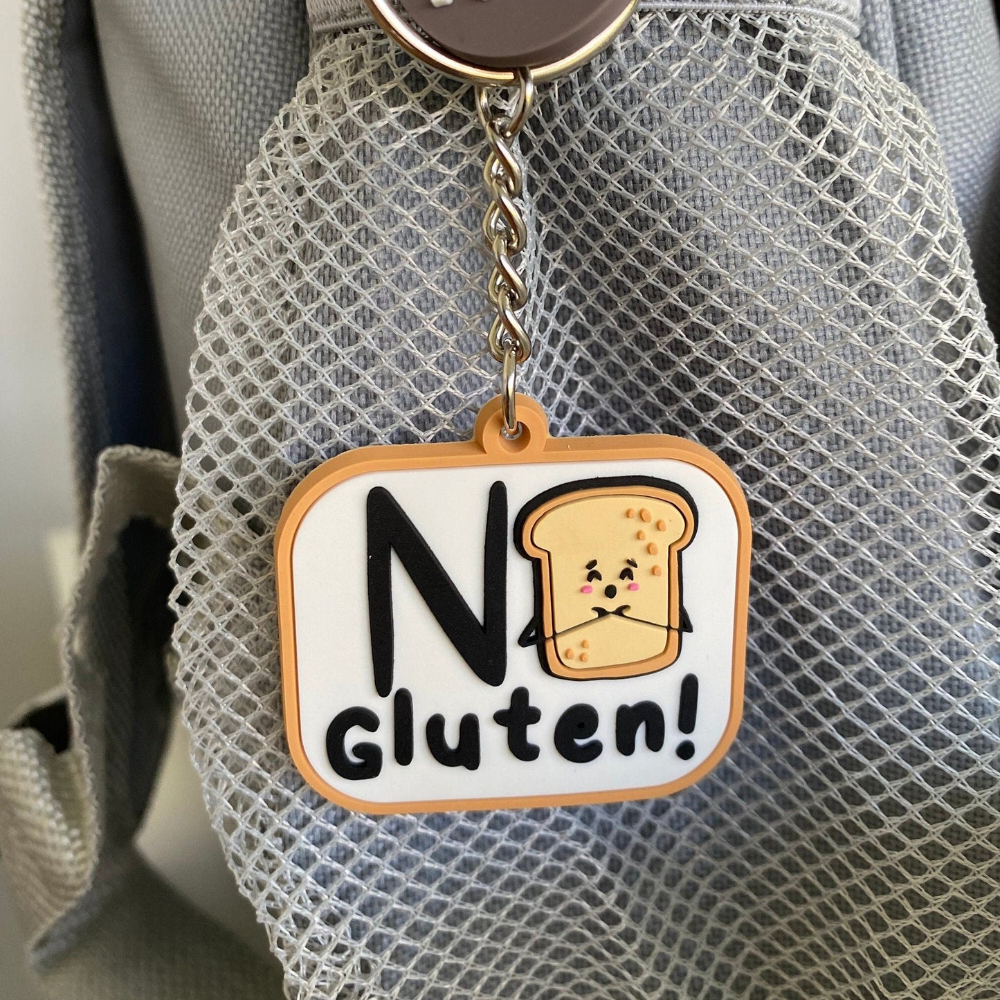 a round dark brown tag reading 'MY 17years' and a square charm that says 'No Gluten!' with a cartoon slice of toast.