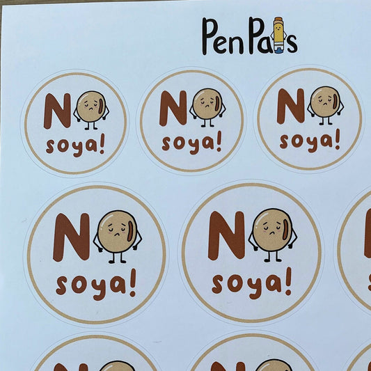 A sheet of circular printed labels or stickers with the text 'No soya!' and a cartoon potato character, placed on a wooden surface. The brand name 'PenPas' is printed at the top.